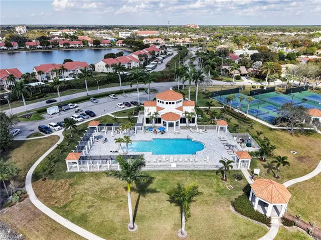 Aerial perspective of suburban area featuring a nearby body of water and a pool