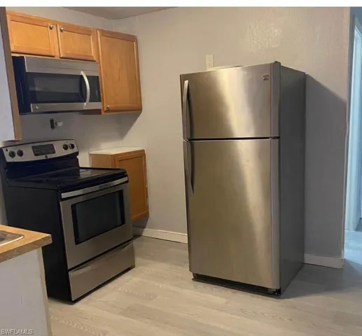 Kitchen featuring appliances with stainless steel finishes and light hardwood / wood-style flooring