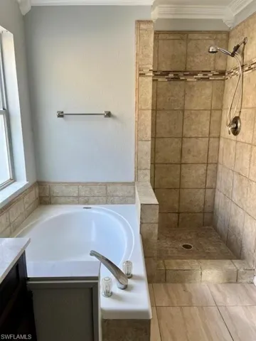 Full bathroom with a tile shower, vanity, and a garden tub
