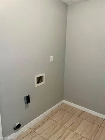 Clothes washing area featuring baseboards, laundry area, and hookup for a washing machine