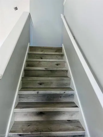 Stairs with visible vents and wood finished floors