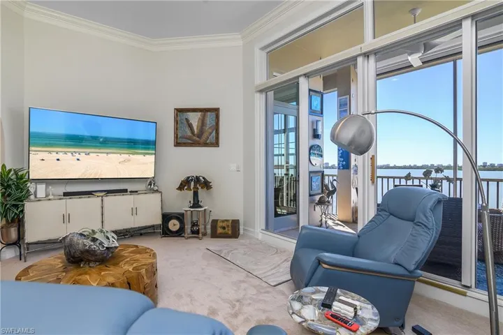 Carpeted living area featuring a water view and ornamental molding