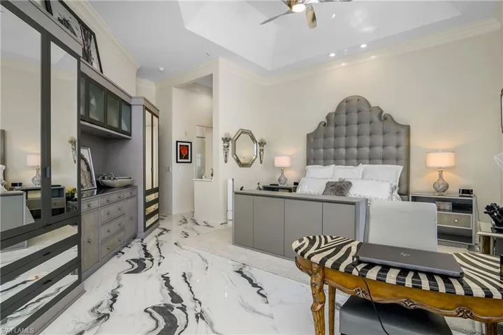 Bedroom featuring marble finish floor and ornamental molding
