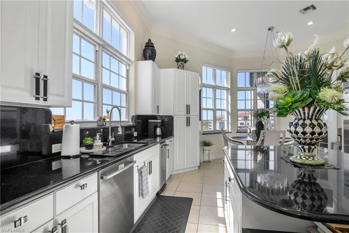Kitchen featuring visible vents, ornamental molding, light tile patterned floors, stainless steel dishwasher, and a sink