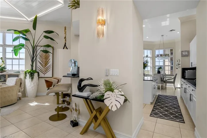 Hallway with baseboards, visible vents, light tile patterned flooring, recessed lighting, and ornamental molding
