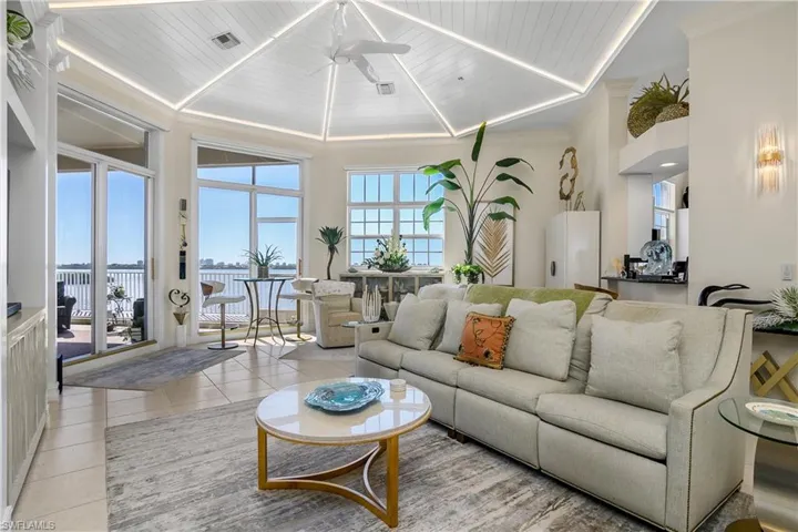 Living area with light tile patterned floors, visible vents, wooden ceiling, and ceiling fan