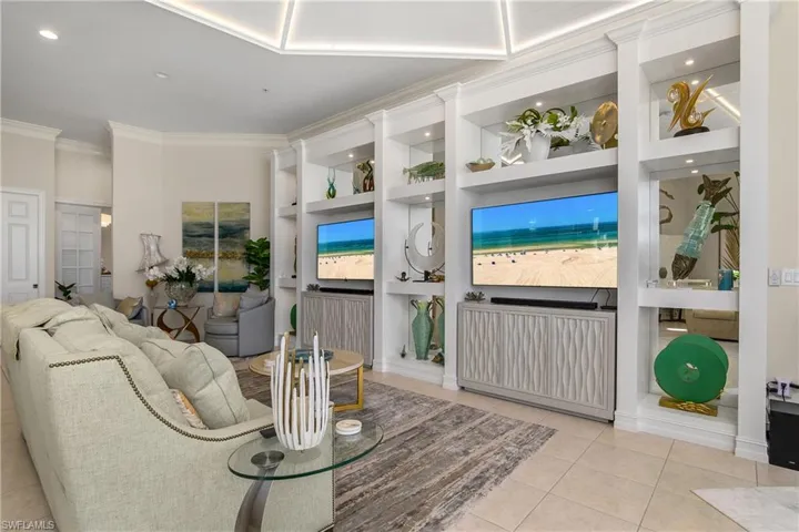 Living room with tile patterned floors, built in features, and crown molding