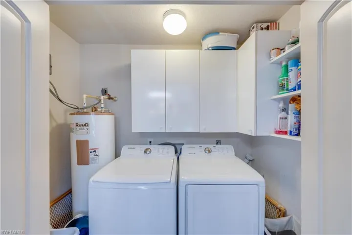155 Evans Rd, LaBelle, FL 33935 Laundry room enclosed in kitchen nook featuring water heater, washer and clothes dryer, and cabinets