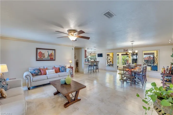 155 Evans Rd, LaBelle, FL 33935 Living room with a textured ceiling, ceiling fan with notable chandelier, and ornamental molding
