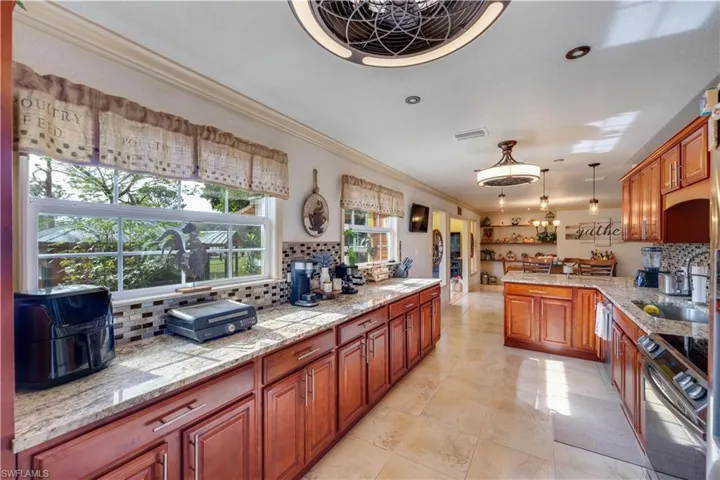 155 Evans Rd, LaBelle, FL 33935 Kitchen with sink, tasteful backsplash, decorative light fixtures, stainless steel range with electric cooktop, and ornamental molding
