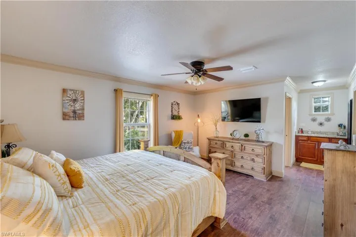 155 Evans Rd, LaBelle, FL 33935 Large bedroom featuring ceiling fan, dark hardwood / wood-style flooring, ornamental molding, and a textured ceiling