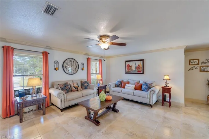 155 Evans Rd, LaBelle, FL 33935 Living room with ceiling fan, a textured ceiling, and ornamental molding
