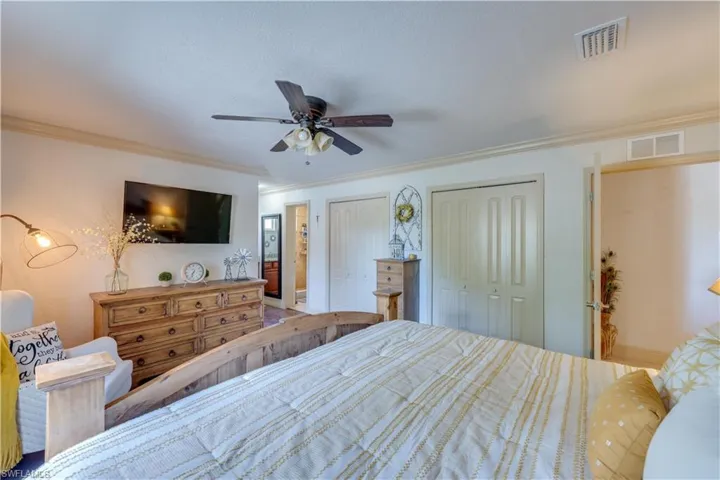 155 Evans Rd, LaBelle, FL 33935 Large bedroom with multiple closets, ceiling fan, and crown molding