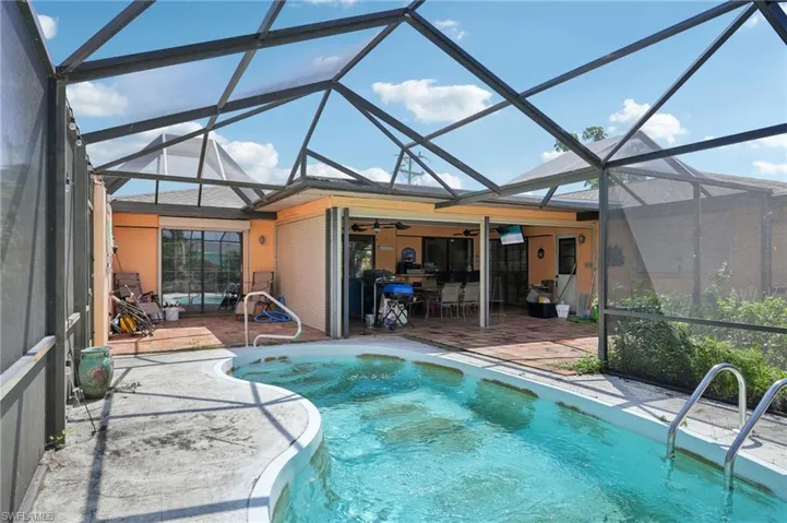 Swimming pool featuring a patio area, a ceiling fan, and a lanai