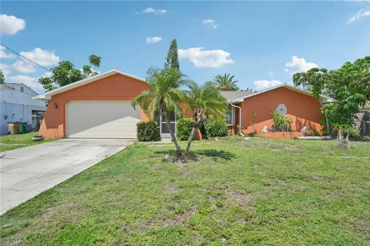 Single story home featuring an attached garage, driveway, and a front yard