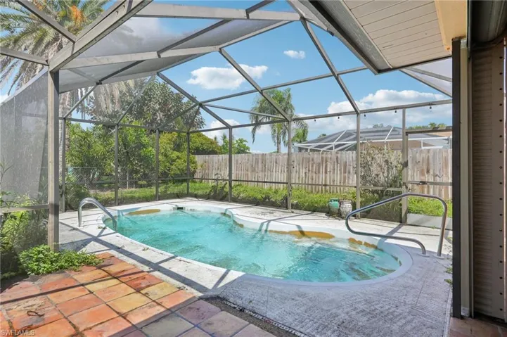 View of pool with a patio and glass enclosure