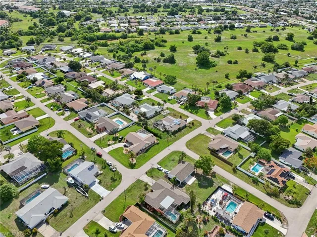 Aerial view of property and surrounding area with nearby suburban area