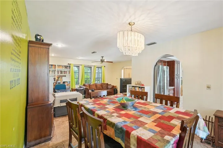 Dining area featuring arched walkways, ceiling fan, and a chandelier