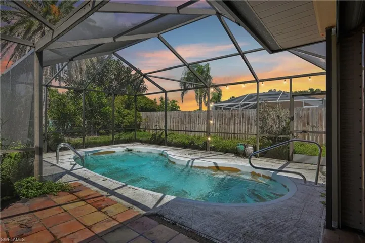 View of swimming pool featuring a patio, a fenced backyard, and a lanai
