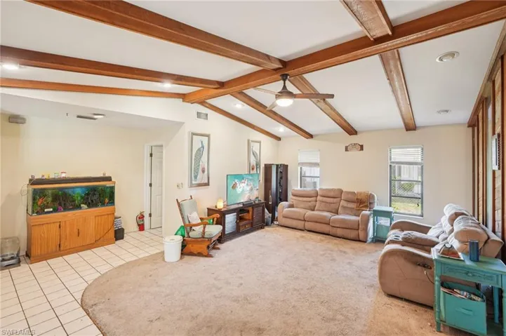 Living room with a ceiling fan, tile patterned floors, and recessed lighting
