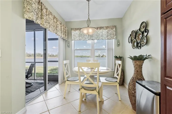 Dining area featuring light tile patterned floors and a water view