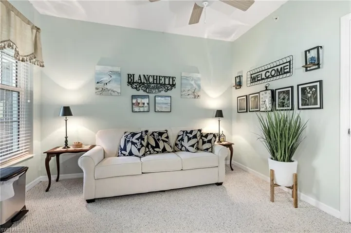 Living area with carpet and a ceiling fan