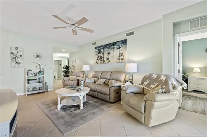 Living area with ceiling fan and light tile patterned floors