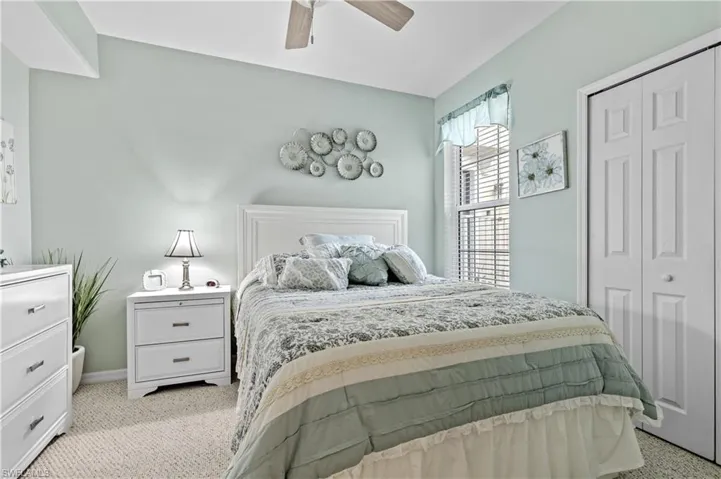 Bedroom featuring light carpet, a closet, and a ceiling fan