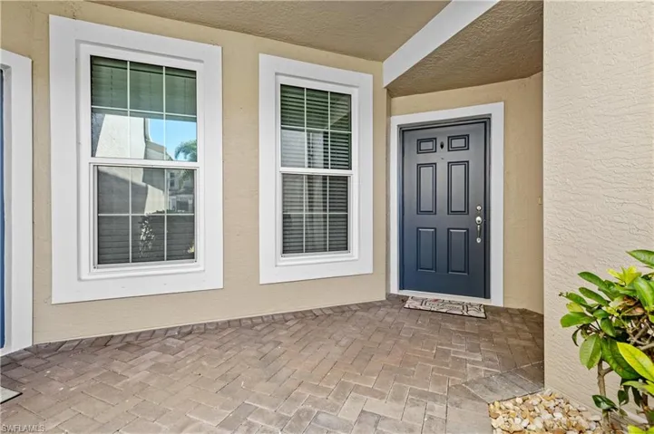 Doorway to property featuring stucco siding