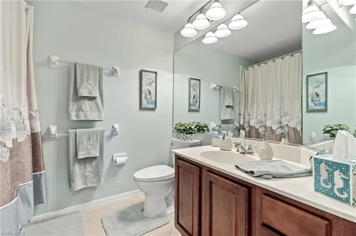 Bathroom with vanity, a shower with shower curtain, and light tile patterned flooring