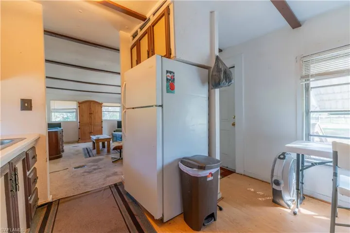 Kitchen featuring light wood-type flooring, white refrigerator, and sink