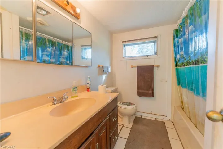 Full bathroom with tile patterned floors, vanity, toilet, and shower / tub combo
