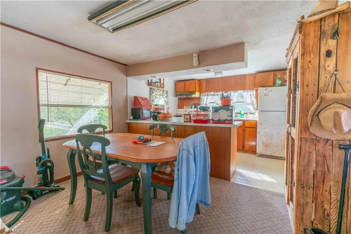 Carpeted dining space with a textured ceiling