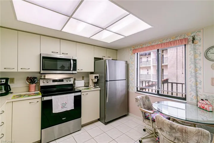 Kitchen with stainless steel appliances, light countertops, and light tile patterned floors