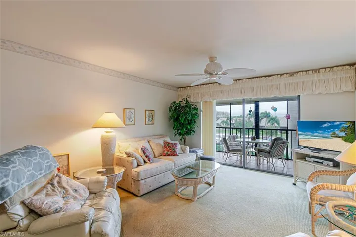 Living area featuring a ceiling fan and light colored carpet