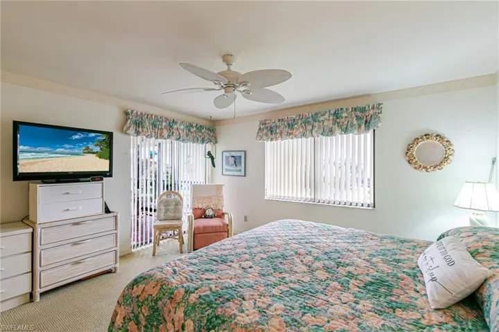 Bedroom with light colored carpet, ceiling fan, and access to exterior