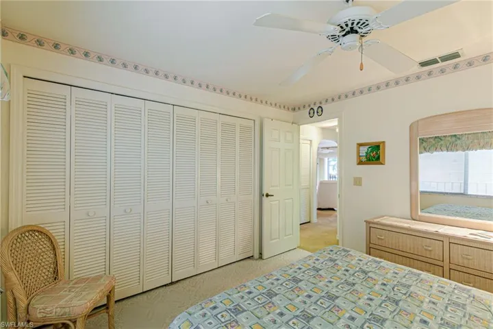 Bedroom featuring a ceiling fan, a closet, and light colored carpet