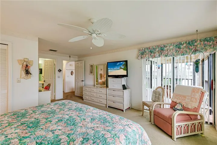 Bedroom featuring light colored carpet, access to exterior, and a ceiling fan