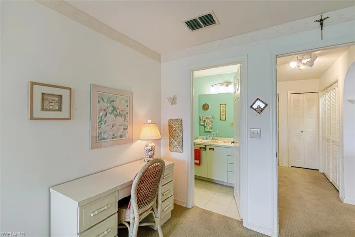 Office area with light colored carpet and a sink