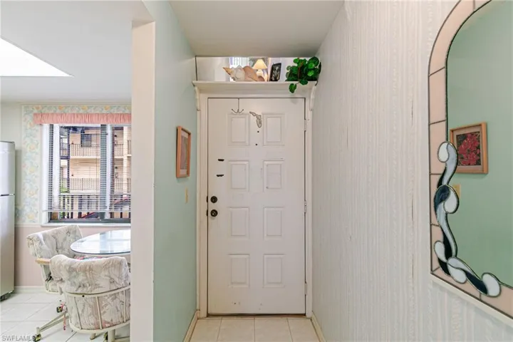 Entrance foyer featuring wallpapered walls and light tile patterned floors