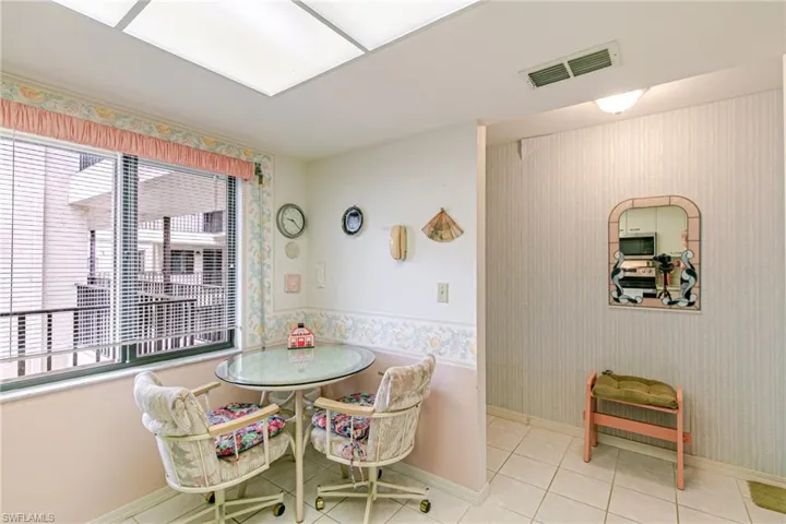 Tiled dining room featuring wallpapered walls and baseboards
