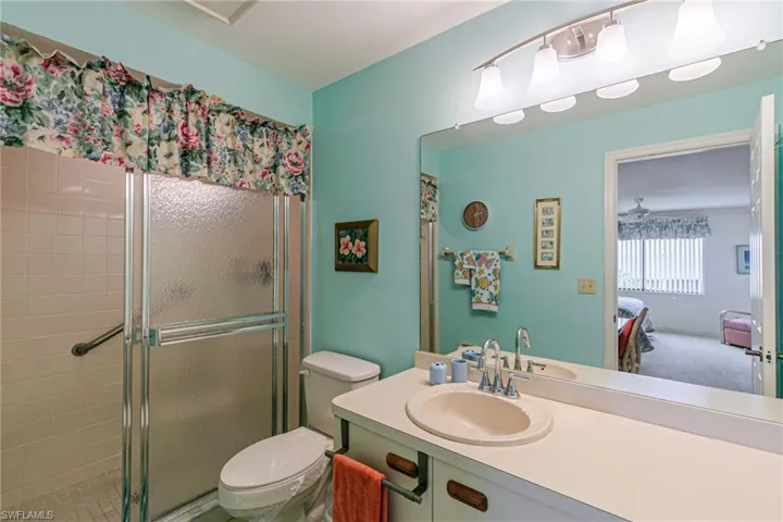 Bathroom featuring vanity, a shower stall, ensuite bath, and a ceiling fan