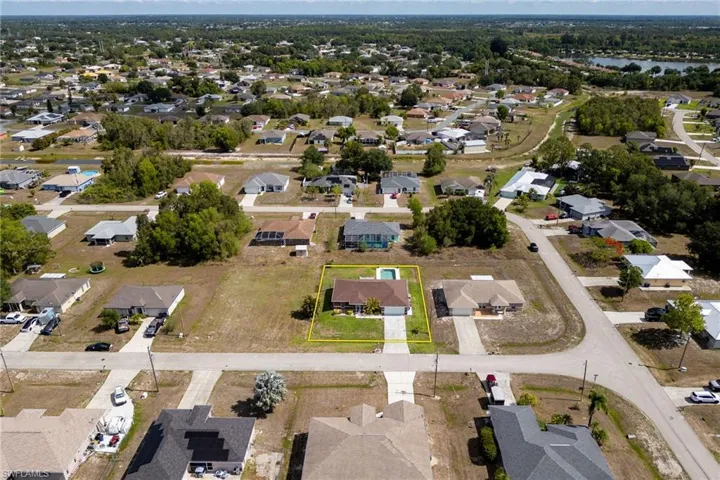 View of property location featuring nearby suburban area, property parcel outlined, and a large body of water