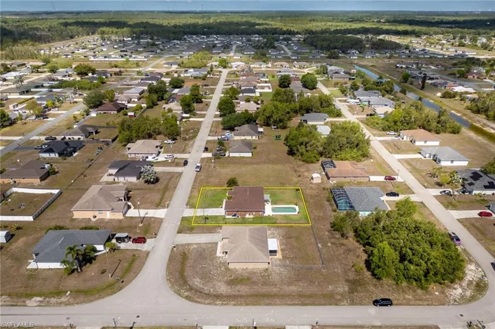 Aerial view of property and surrounding area featuring nearby suburban area