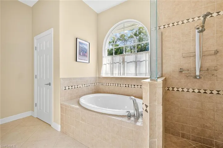 Bathroom with a garden tub, a walk in shower, and tile patterned flooring