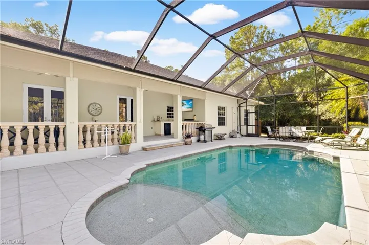 Swimming pool featuring a patio area and glass enclosure