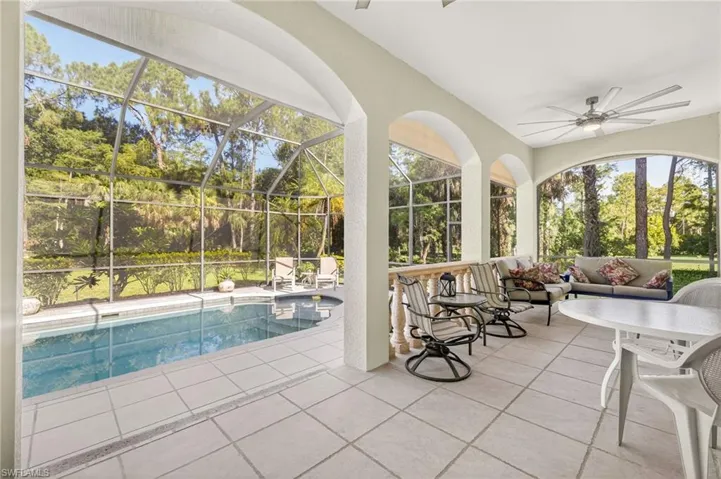 Outdoor pool with a patio area, a ceiling fan, a lanai, and an outdoor living space