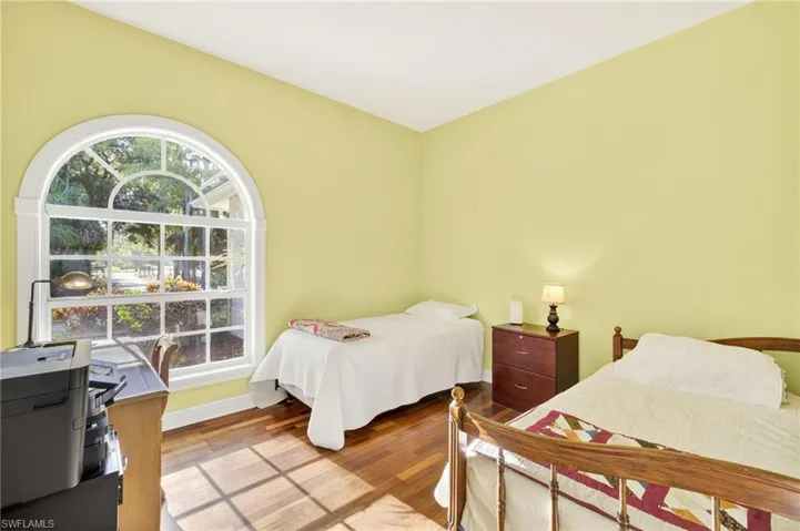 Bedroom with wood finished floors and baseboards