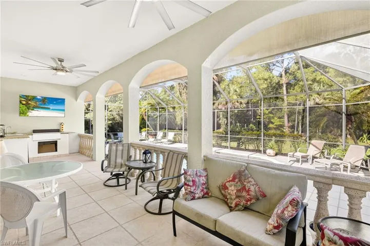 Sunroom with ceiling fan, an outdoor kitchen, and outdoor lounge area