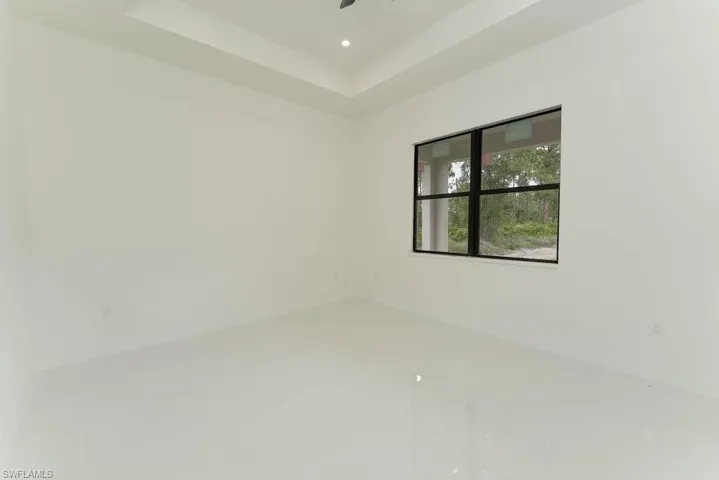 Empty room featuring ceiling fan, recessed lighting, and a tray ceiling